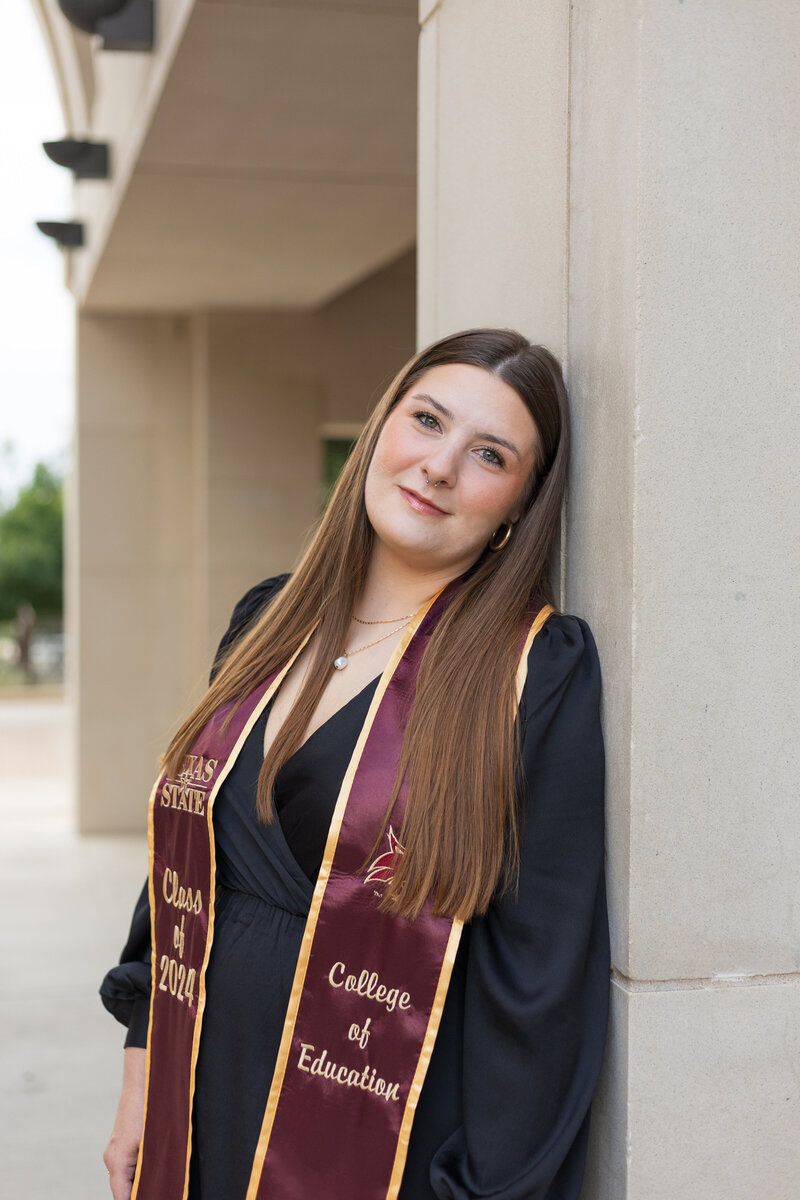 Karlee poses in senior jacket for graduation photos in Houston