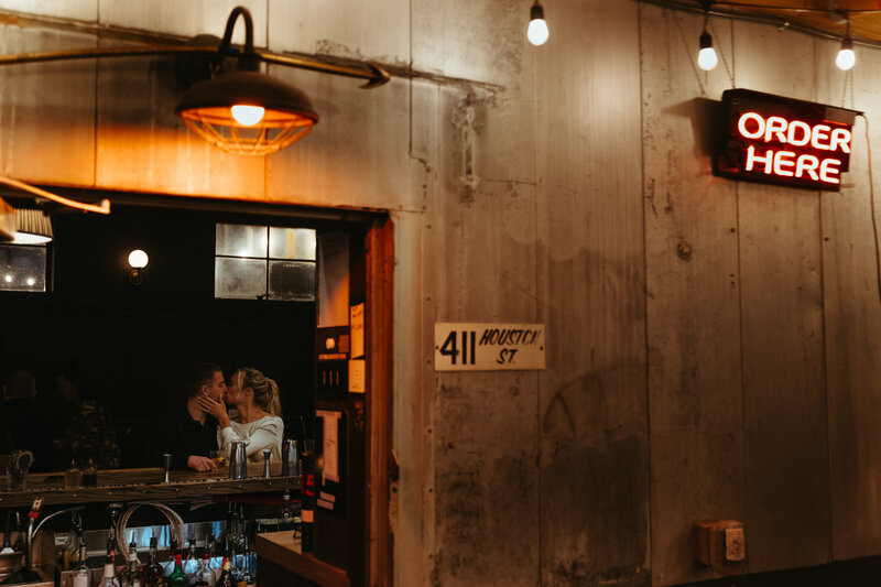 couple kisses at bar
