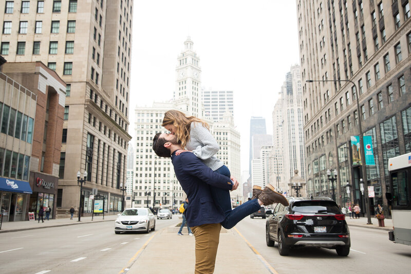 couple on michigan avenue kissing after surprise proposal in downtown chicago