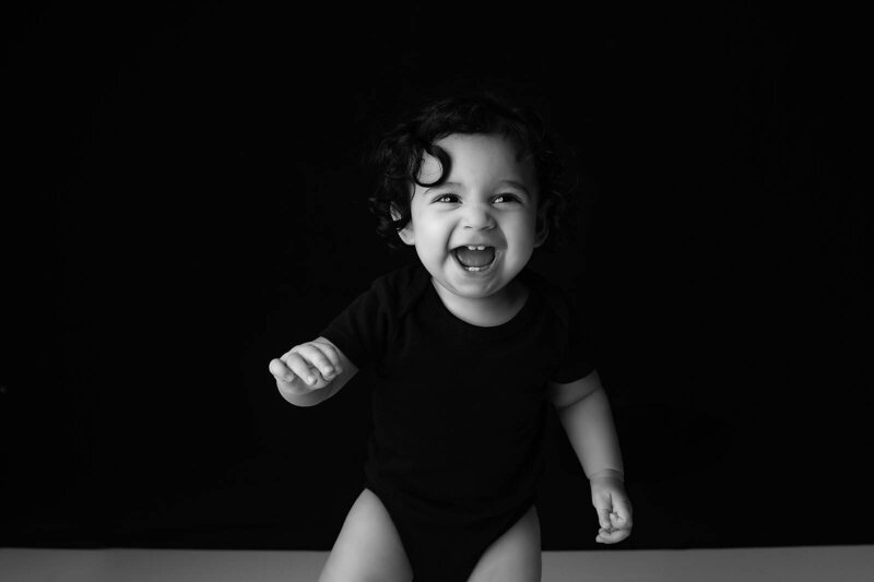 A coquitlam Photographer captures an image of a smiling baby in black and white