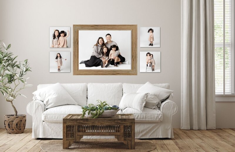 family portraits displayed above a white couch in a neutral living room