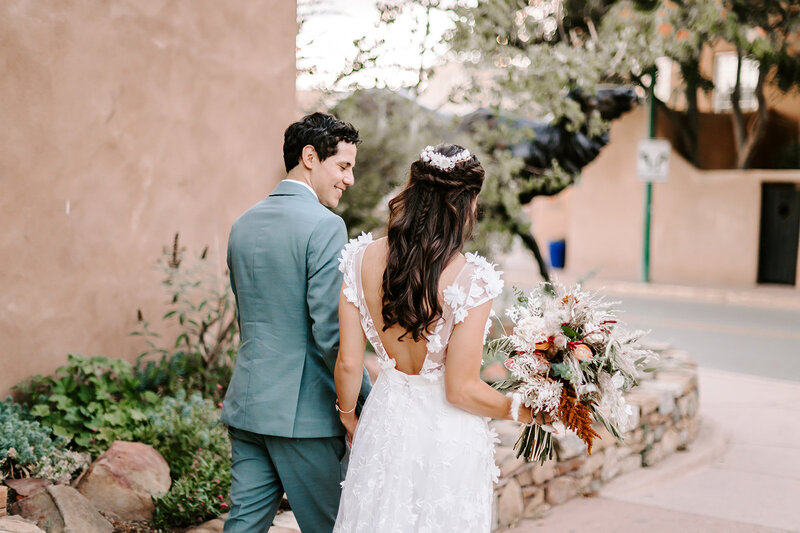 Bride and groom holding hands walking the Santa Fe Plaza
