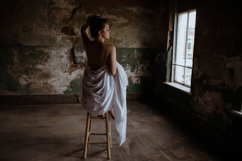 woman on stool wrapped in sheet