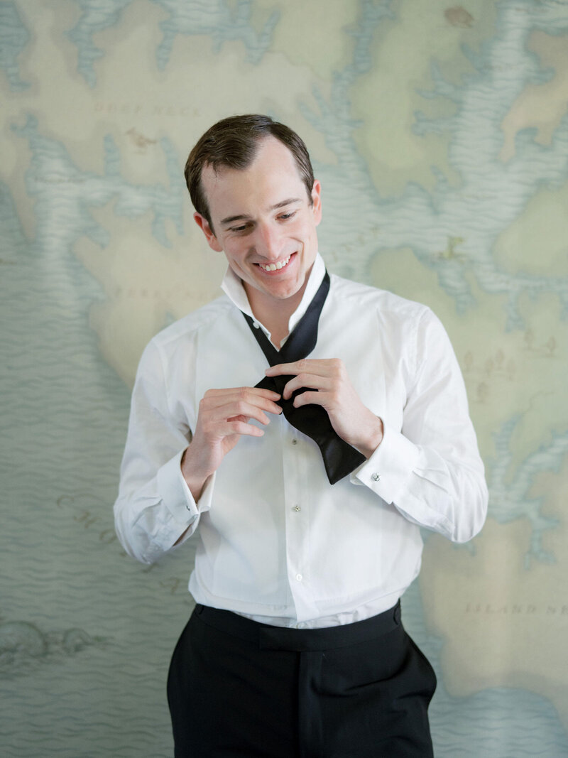 Portrait of groom tying bow tie