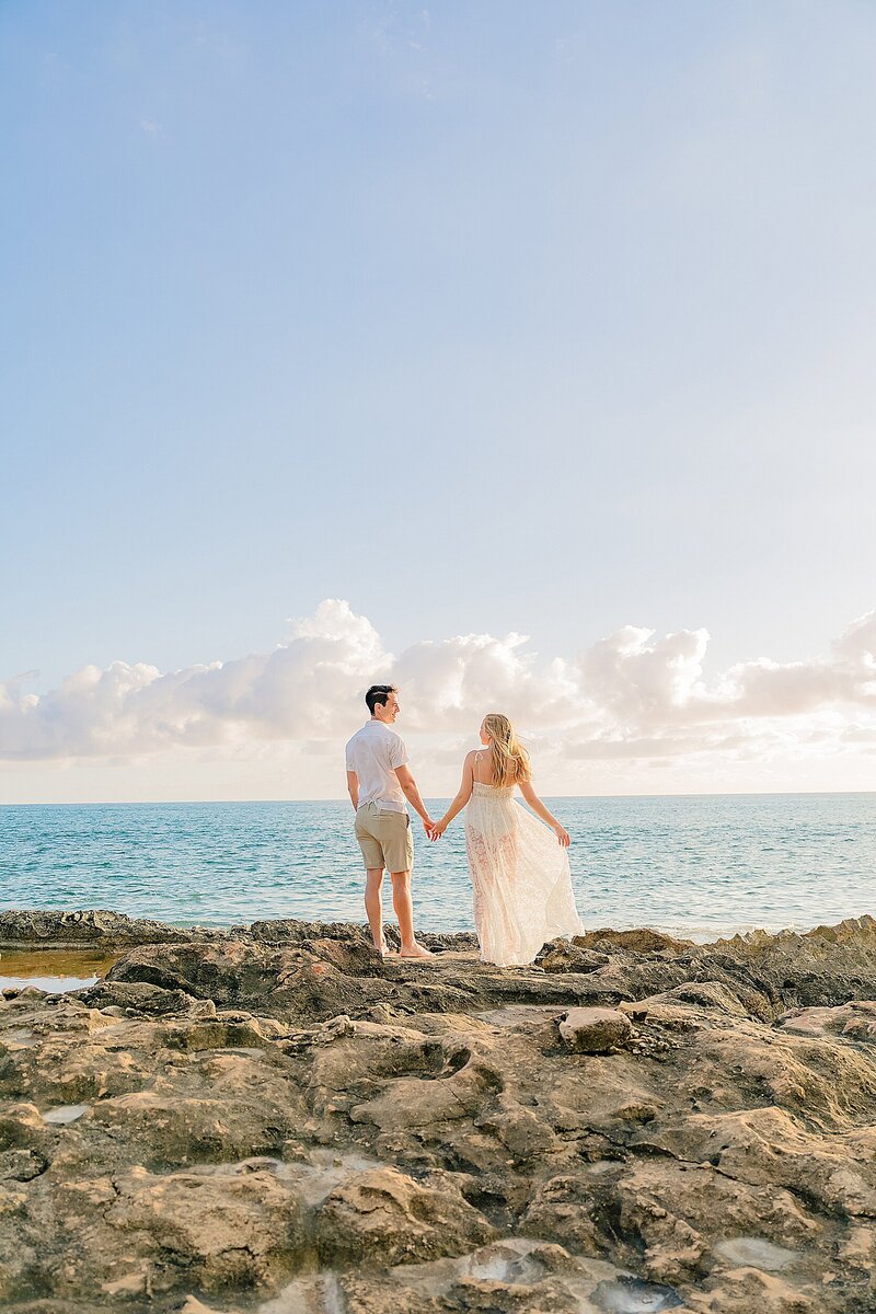 couple expecting their first child posing for oahu babymoon portraits with love and water
