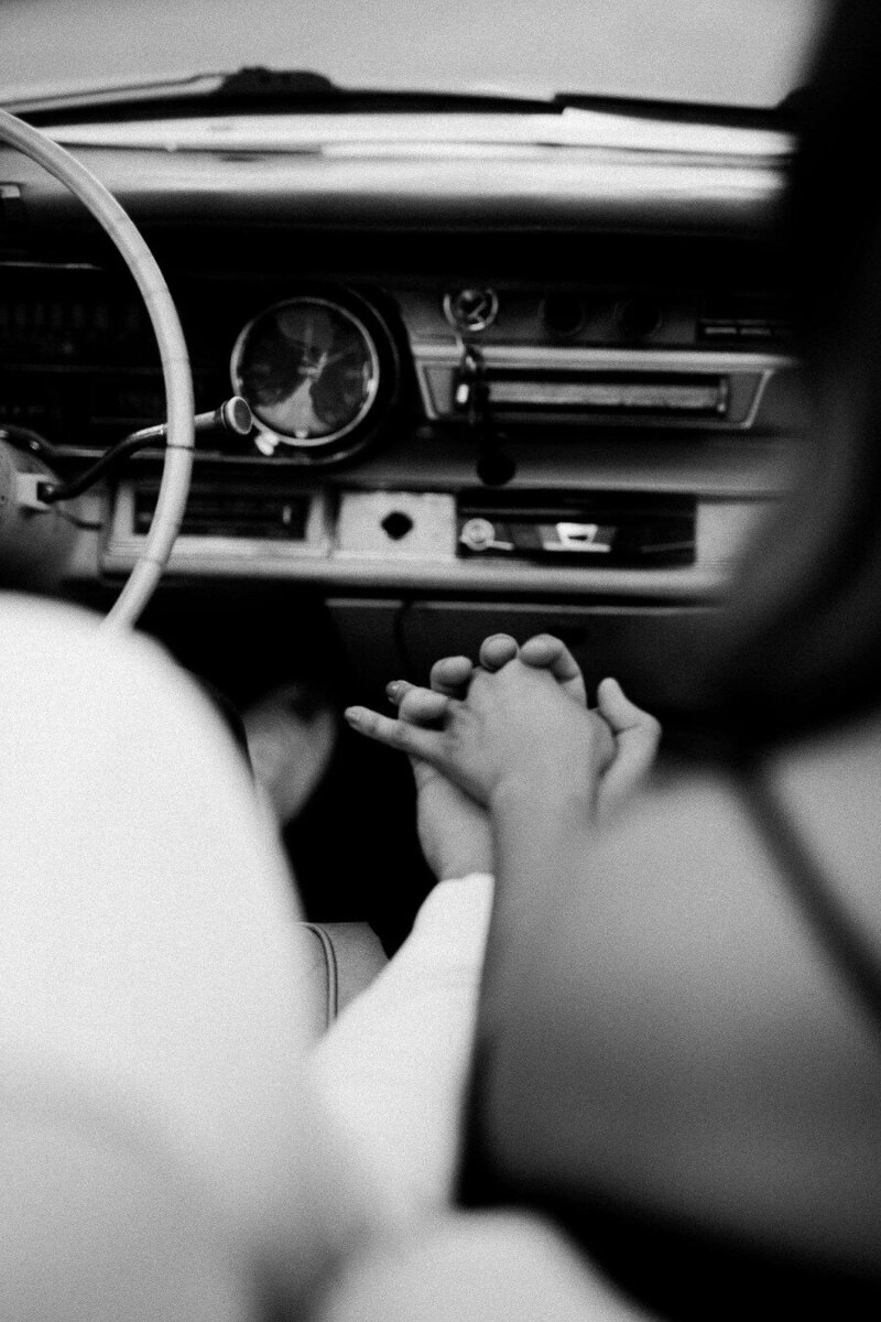 Couple holding hands driving in car