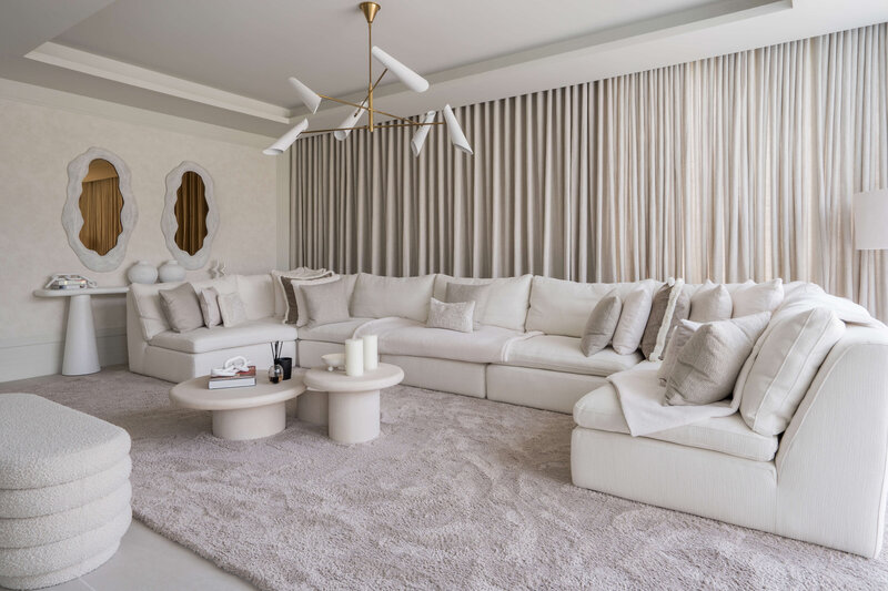 living room with large white sectional decorated in white and neutrals