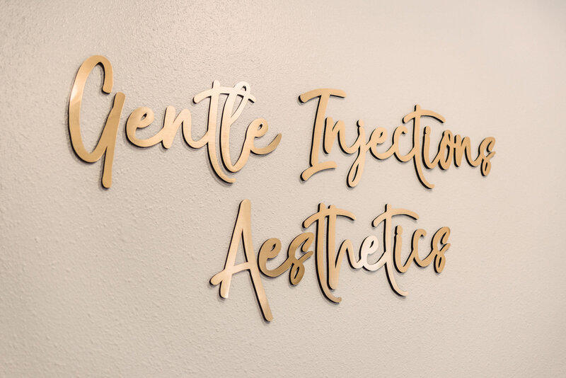 gentle injections aesthetics gold words on a wall