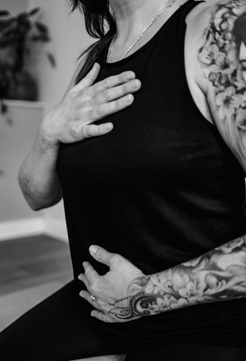 Image of a Nat Winterson of Studio Eight yoga studio n Wells, Somerset practising breathwork with hands on body