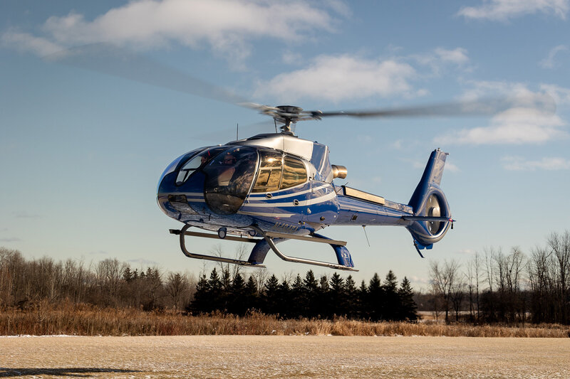 blue airbus ec130 b4 helicopter flying in sky - high-end private aircraft transport