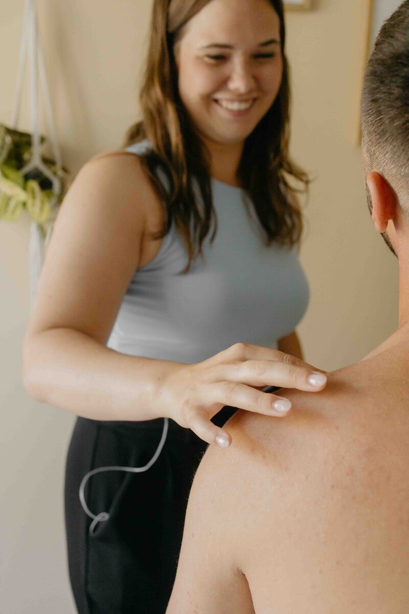 Femme exerçant une pression sur l’épaule d’un homme lors d’un soin