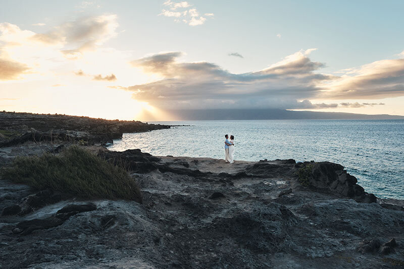 Couple embraces on the cliffs of Maui during sunset