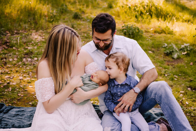 Outdoor lifestyle newborn photography in San Diego during golden hour in a field.