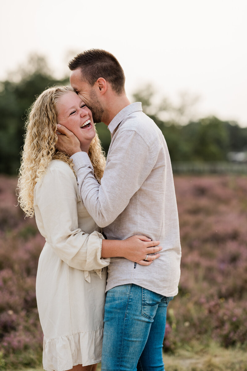 Een stel deelt een vrolijk moment tijdens een loveshoot in de natuur, vastgelegd door Monica Stout Fotografie in een ontspannen setting.