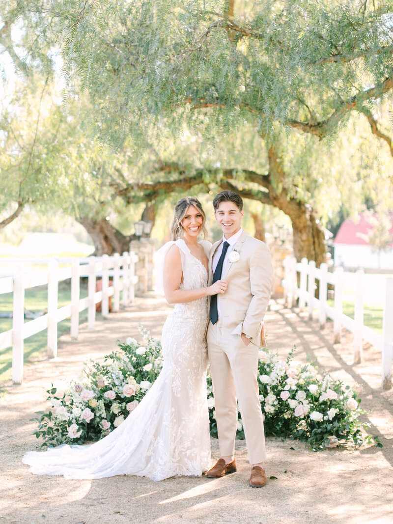 wedding portrait of bride and groom in front of floral ceremony space