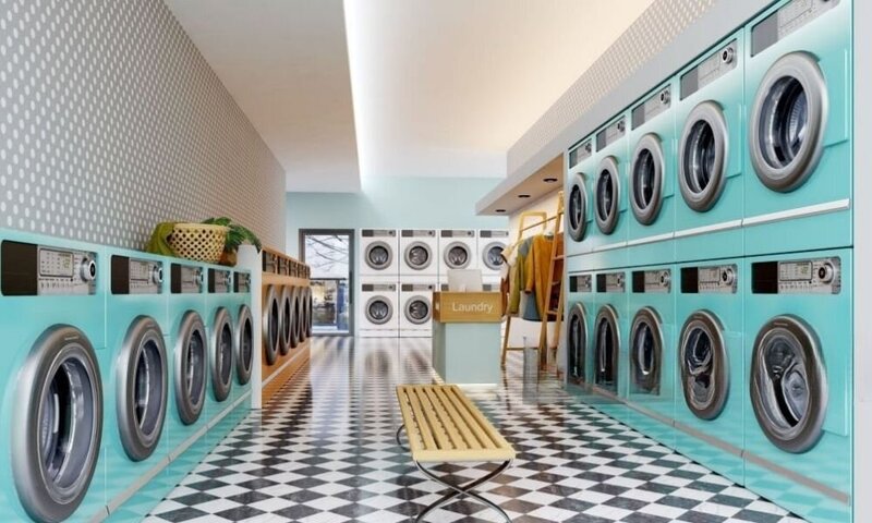 a laundry mat with a row of teal blue dryers