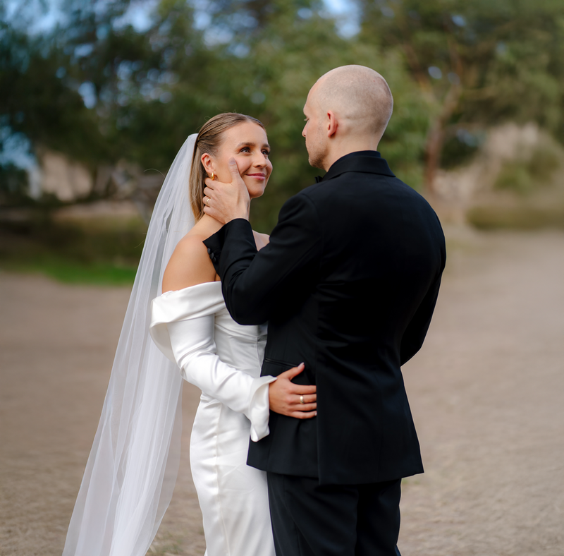 A bride and groom holding each other and looking into each other eyes