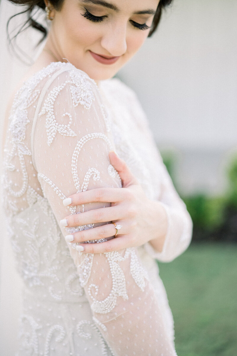 detail of bride's hands on beaded dress at the grand ivory venue in texas