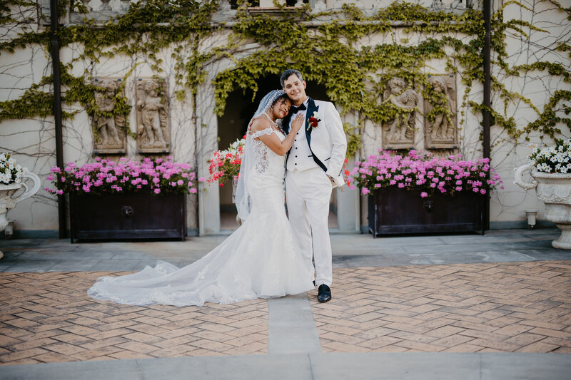 Full-length wedding couple, both dressed in white, at Tenuta Corbinaia.