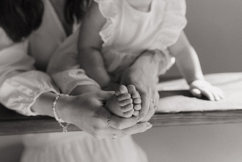 mom holding baby's feet during studio newborn photoshoot captured by NYC newborn photographer Elsie Goodman 