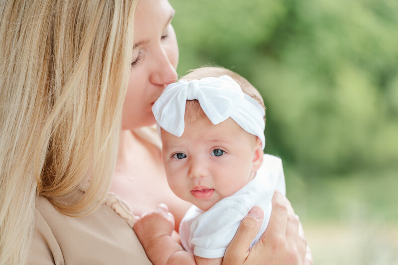 mother kissing baby by baltimore newborn photographer