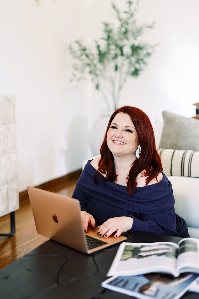 Anna Delores founder, Emily, smiles while sitting in chair in white dress