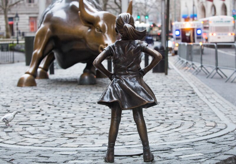 Statue of little girl standing in front of bull - located in front of Wall Street, New York
