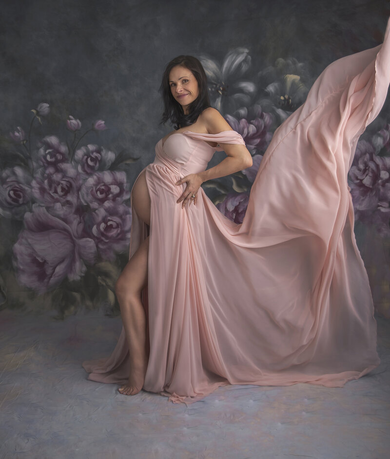 "Pregnant mom in a stunning gown, captured in a graceful fabric toss, showcasing elegance and movement in a fine art maternity photography session in Ottawa."