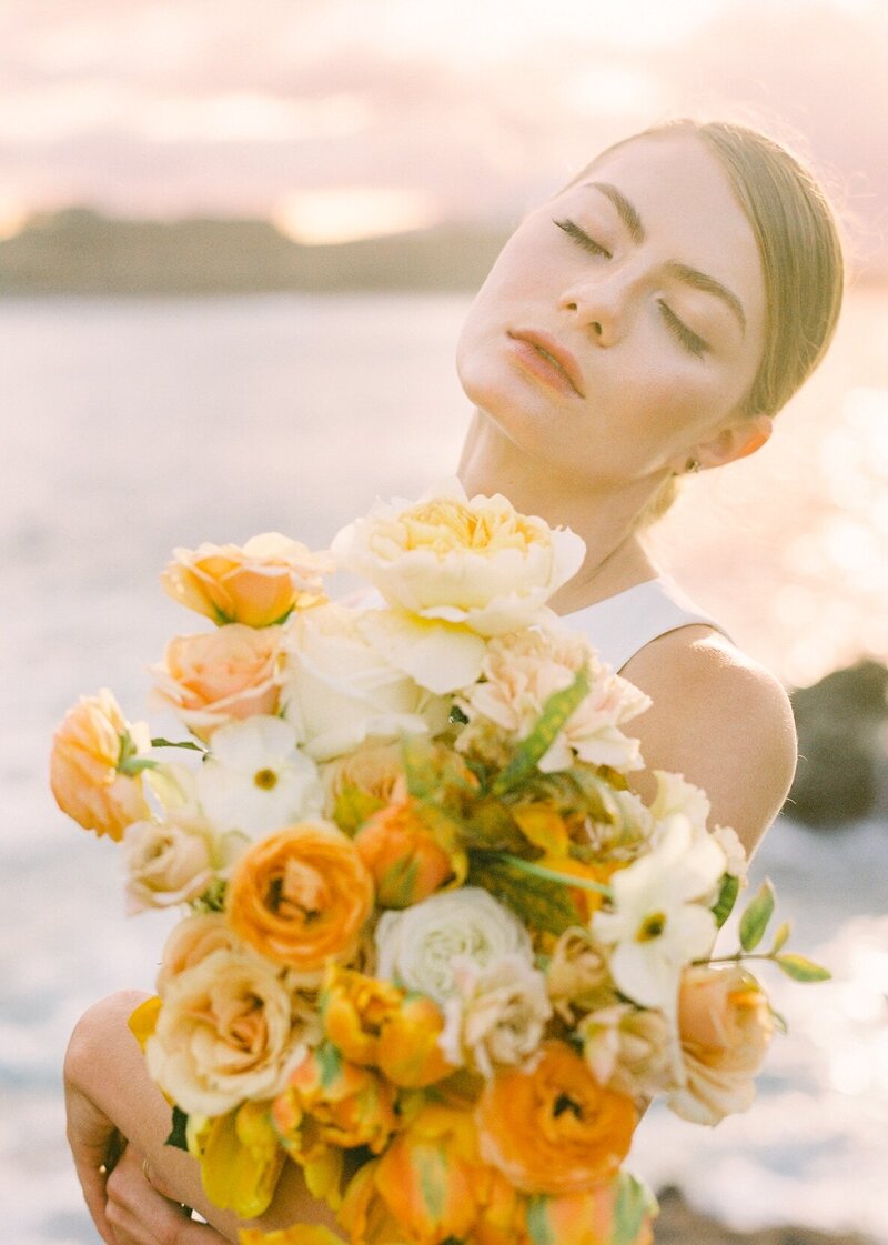 Bride with orange flowers at Maui's North Shore for golden hour elopement