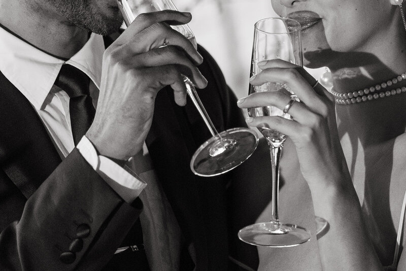 close up black and white photo of bride and groom drinking champagne