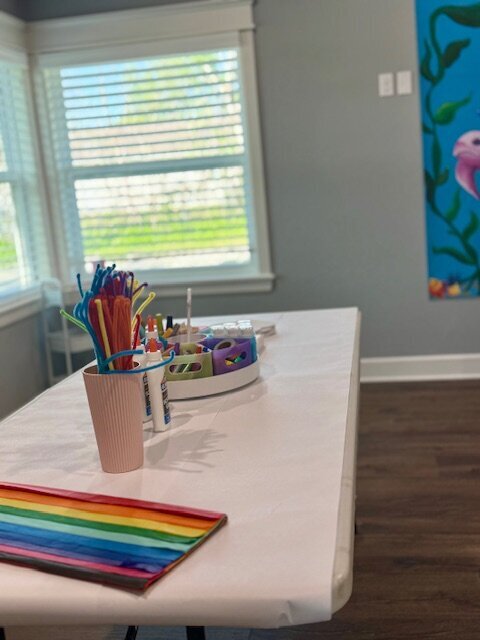  A young child sits at a table with a tutor, smiling while reading a book, representing personalized literacy support at The Learning Lounge in Oklahoma.
