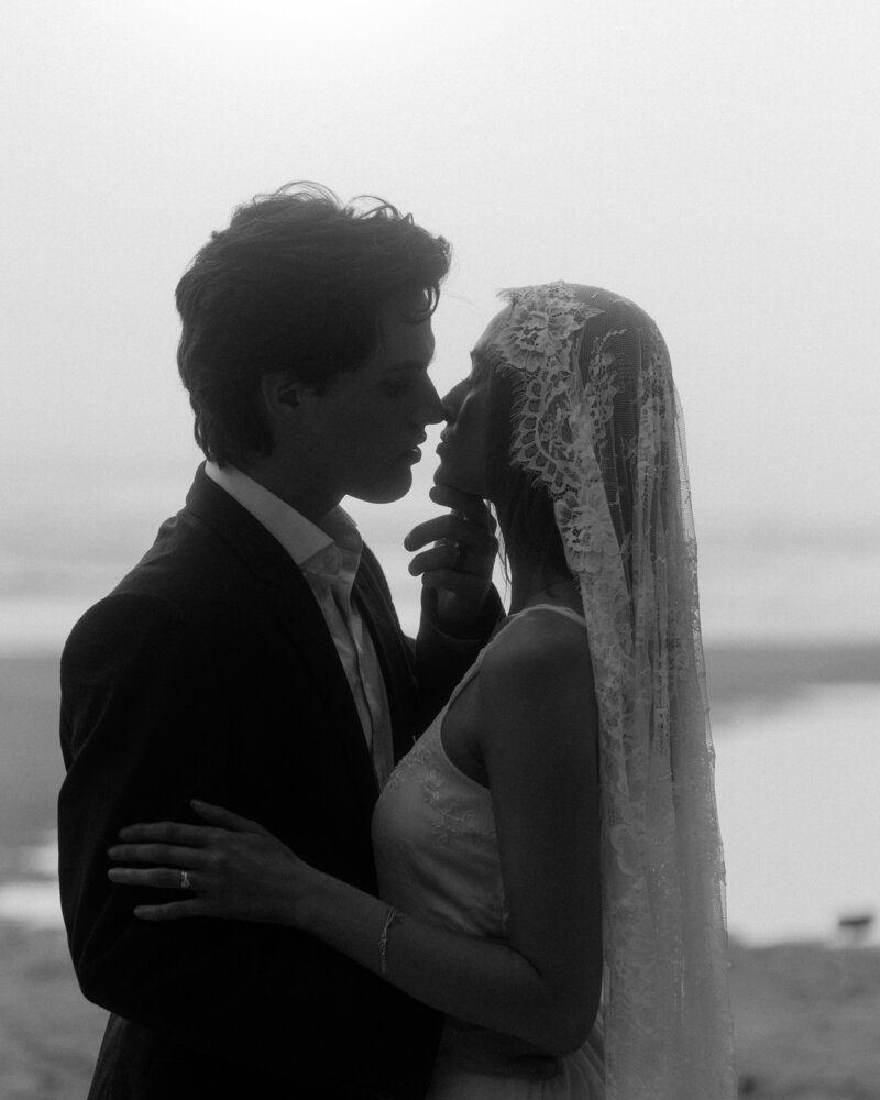 husband and wife kiss on the beach