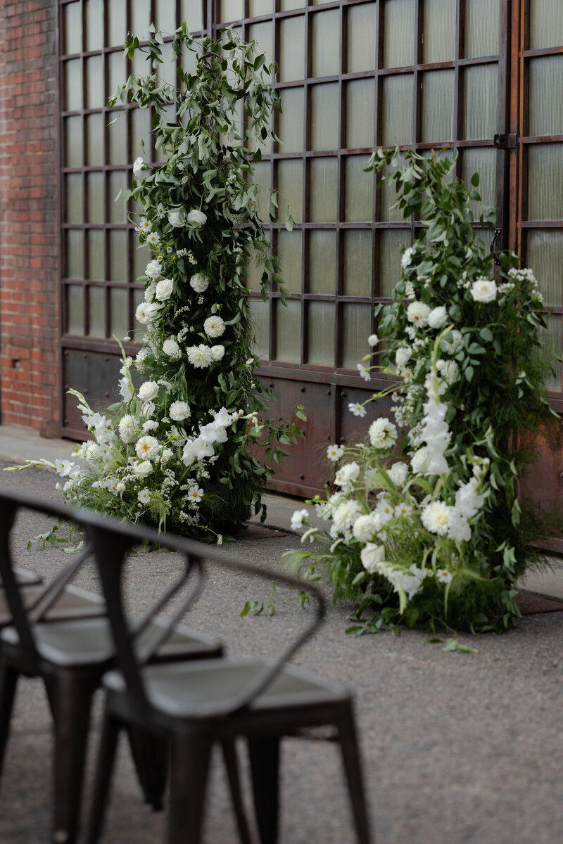 Modern floral arch providing backdrop at Blanc, Denver wedding venue