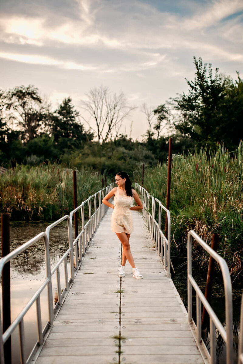 Senior girl standing on a metal dock.