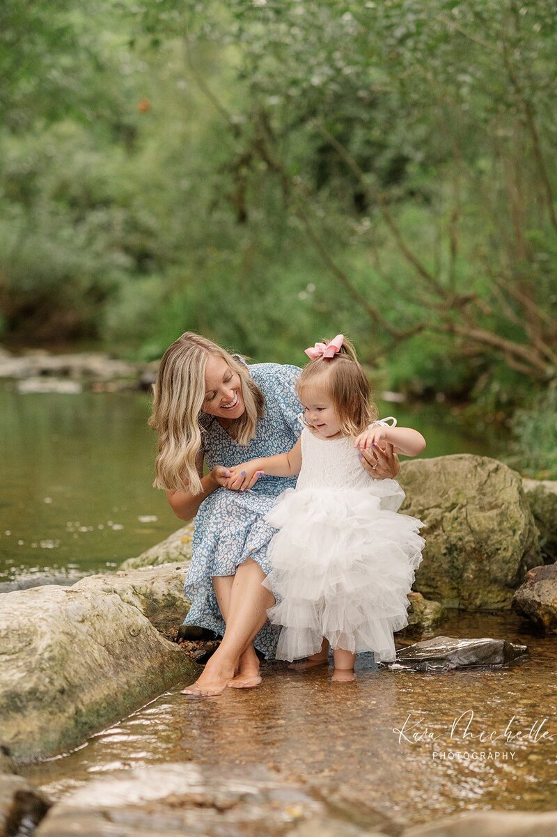 mother and daughter in white fluffy dress in a creek at mill creek preserve by york pa photographer