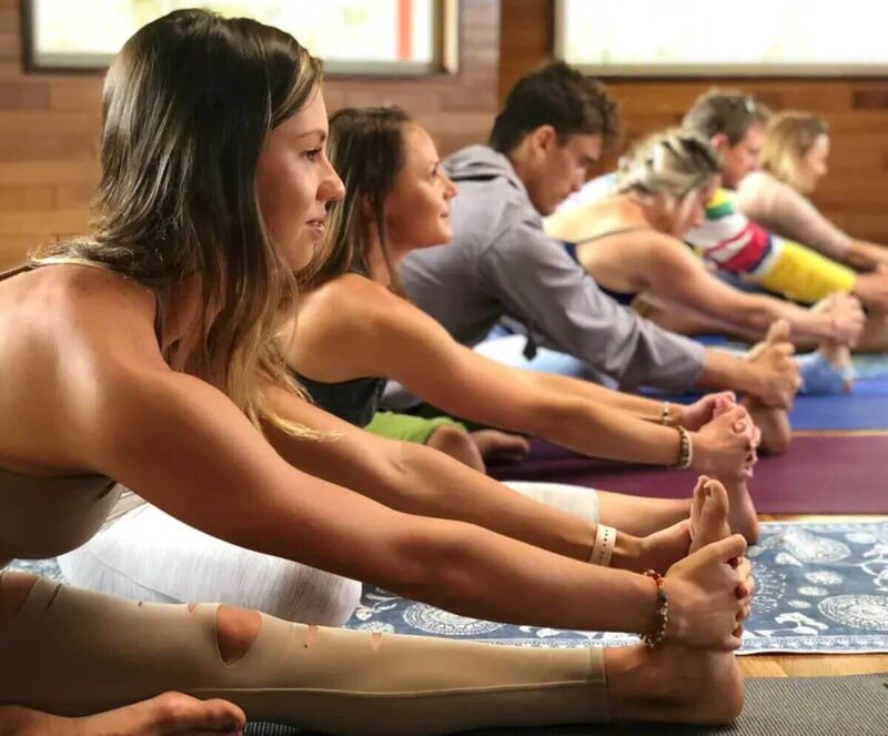 Students in janu sirsasana head-to-knee pose during hatha yoga teacher training California