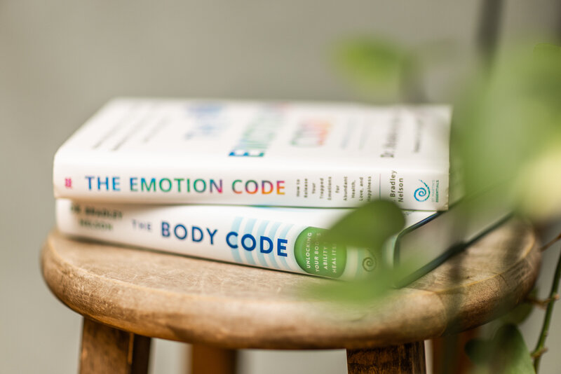 emotion code and body code book sitting on a wooden stool