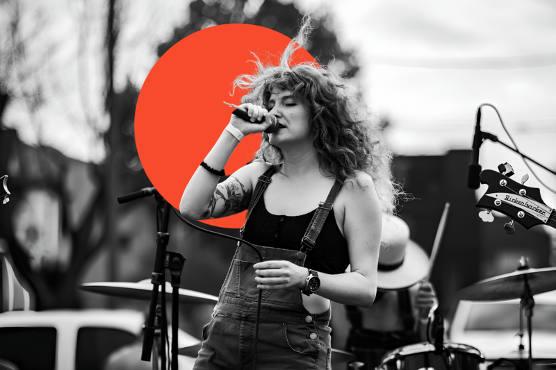 Allison on stage at the Moontower Anniversary festival in Houston, Texas, singing into a microphone.
