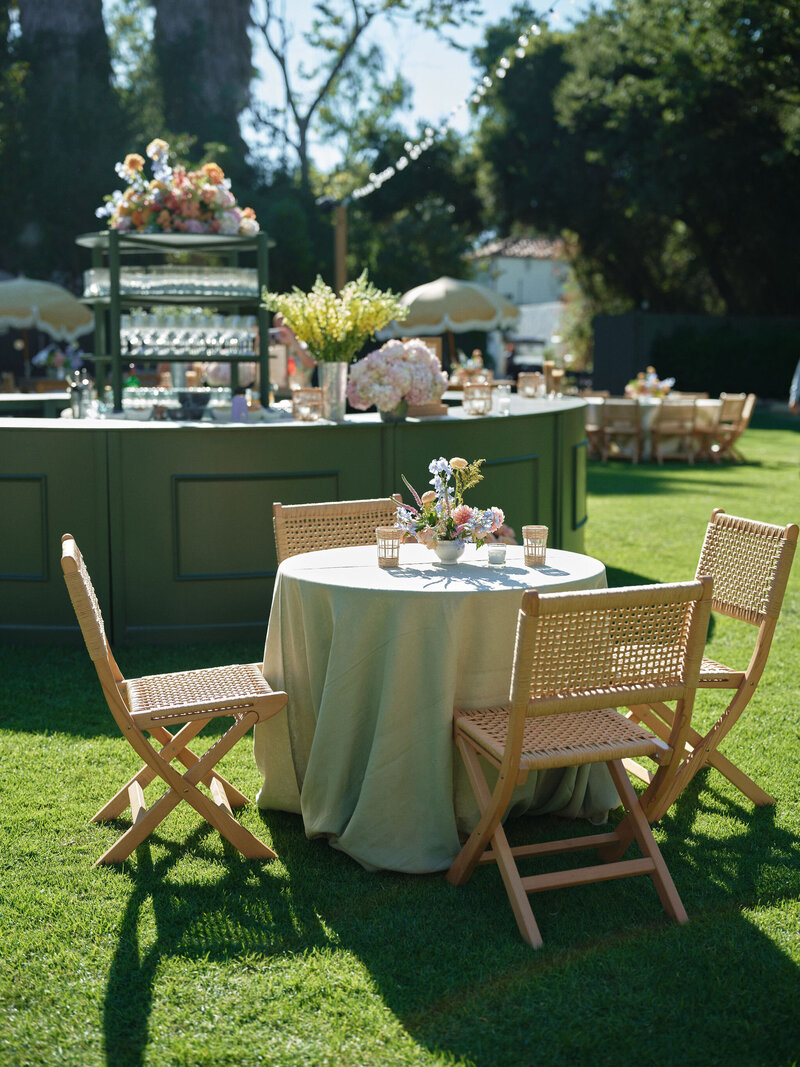 outdoor wedding welcome dinner on a porch outdoors with a long table and fairy lights