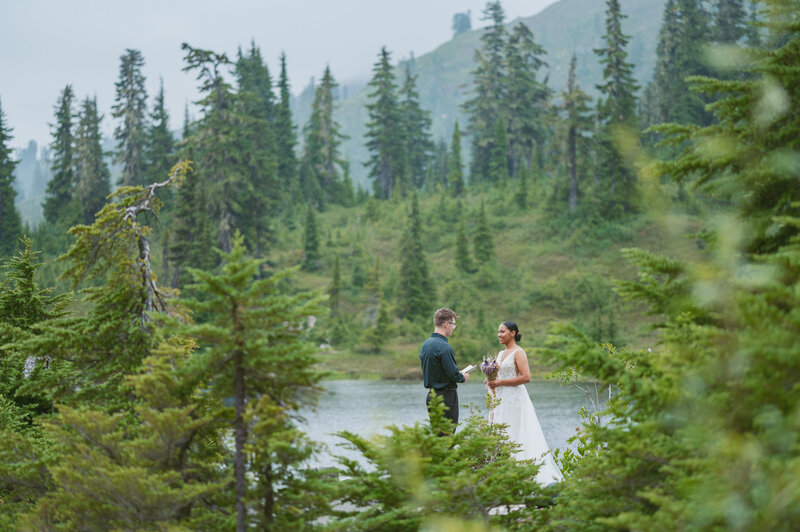 a married couple kissing middle of forest