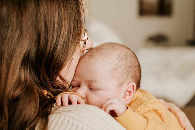 mom kissing newborn baby's head 