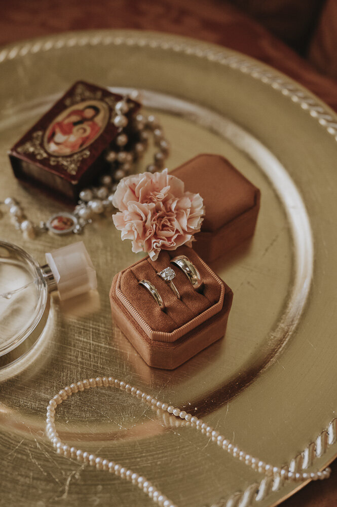 wedding rings,  a perfume bottle, a flower, and other wedding details