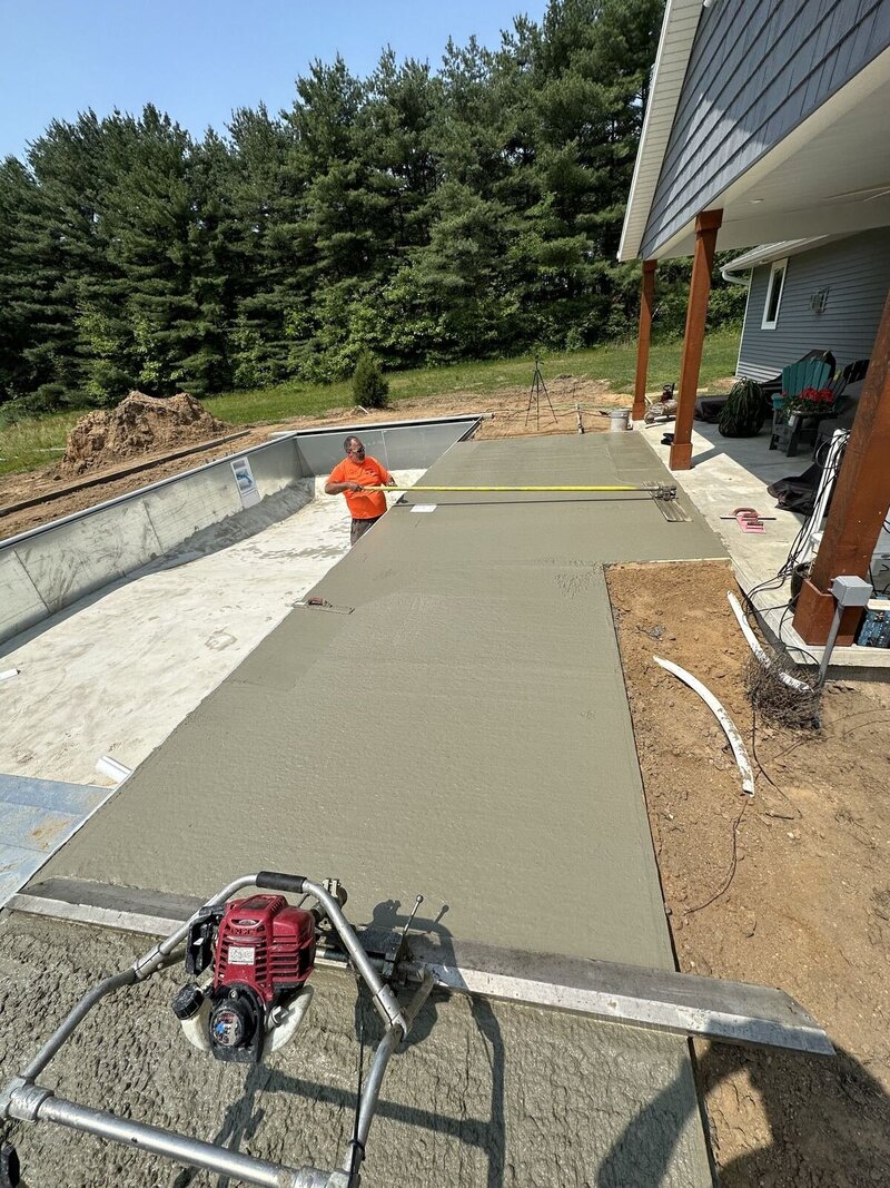 Pool deck finishing: power screed leveling the fresh deck along the pool in Elkhart, IN