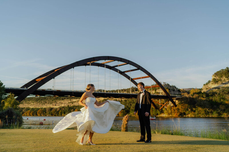 Groom holds his wife and twirls her around with the mountains behind them