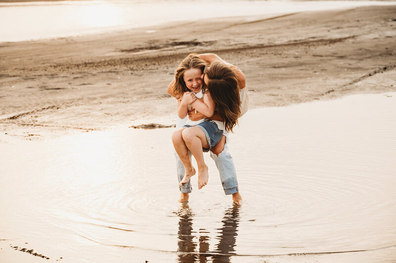 A mom and her mini me dance around in the shallow waters at the recreation area of the desert near bismarck, nd