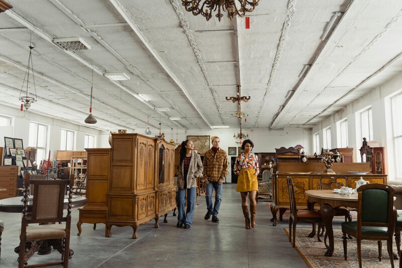 Team walking through a vintage furniture showroom for Nova Lux DR’s design consultation
