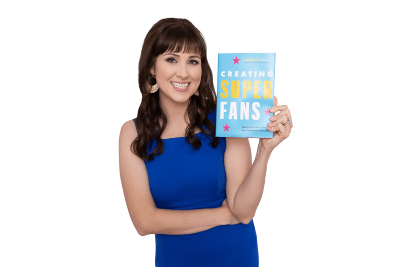 Brittany Hodak posing with the hardcover of her book, Creating Superfans: how to turn your customers into lifelong advocates.