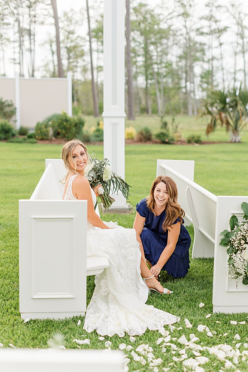 Photographer helping a bride put her shoes on