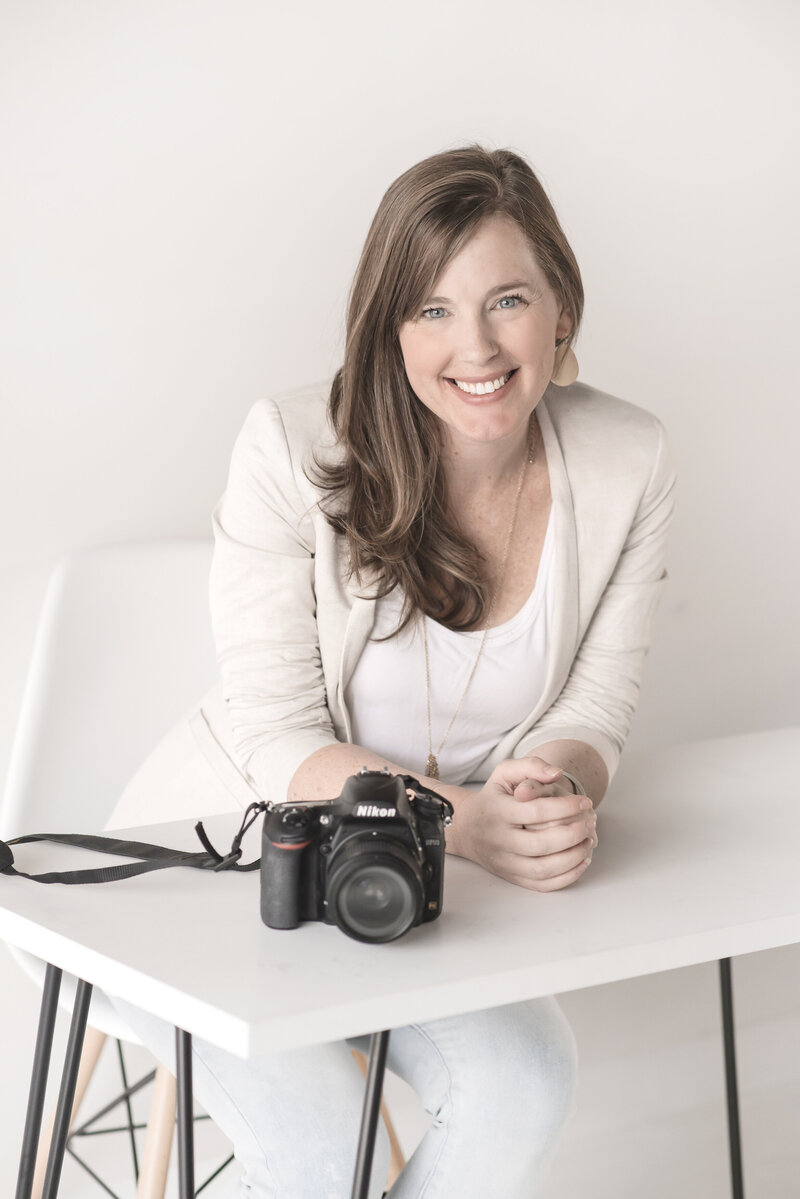 Jessica Lee smiling with camera setting on desk