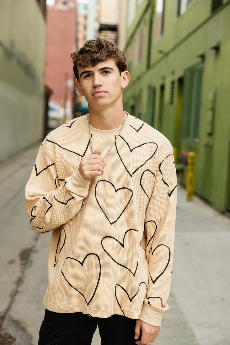 Teen guy posing in urban location for stylish and cinematic senior photos in SoCal.

